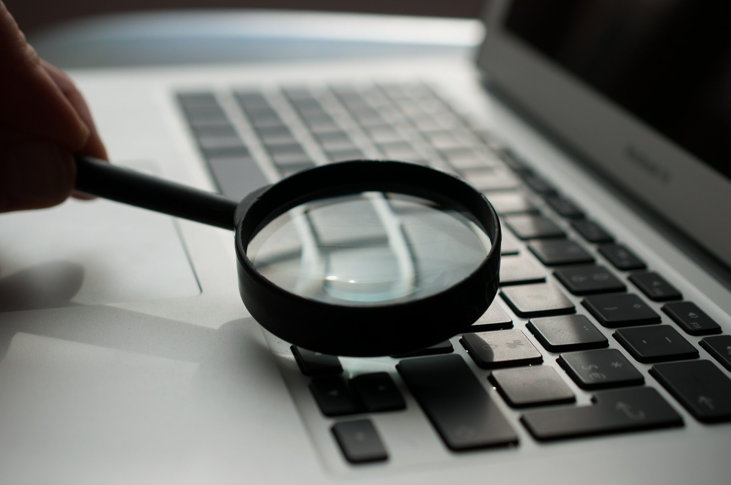 magnifying glass looking over laptop keyboard