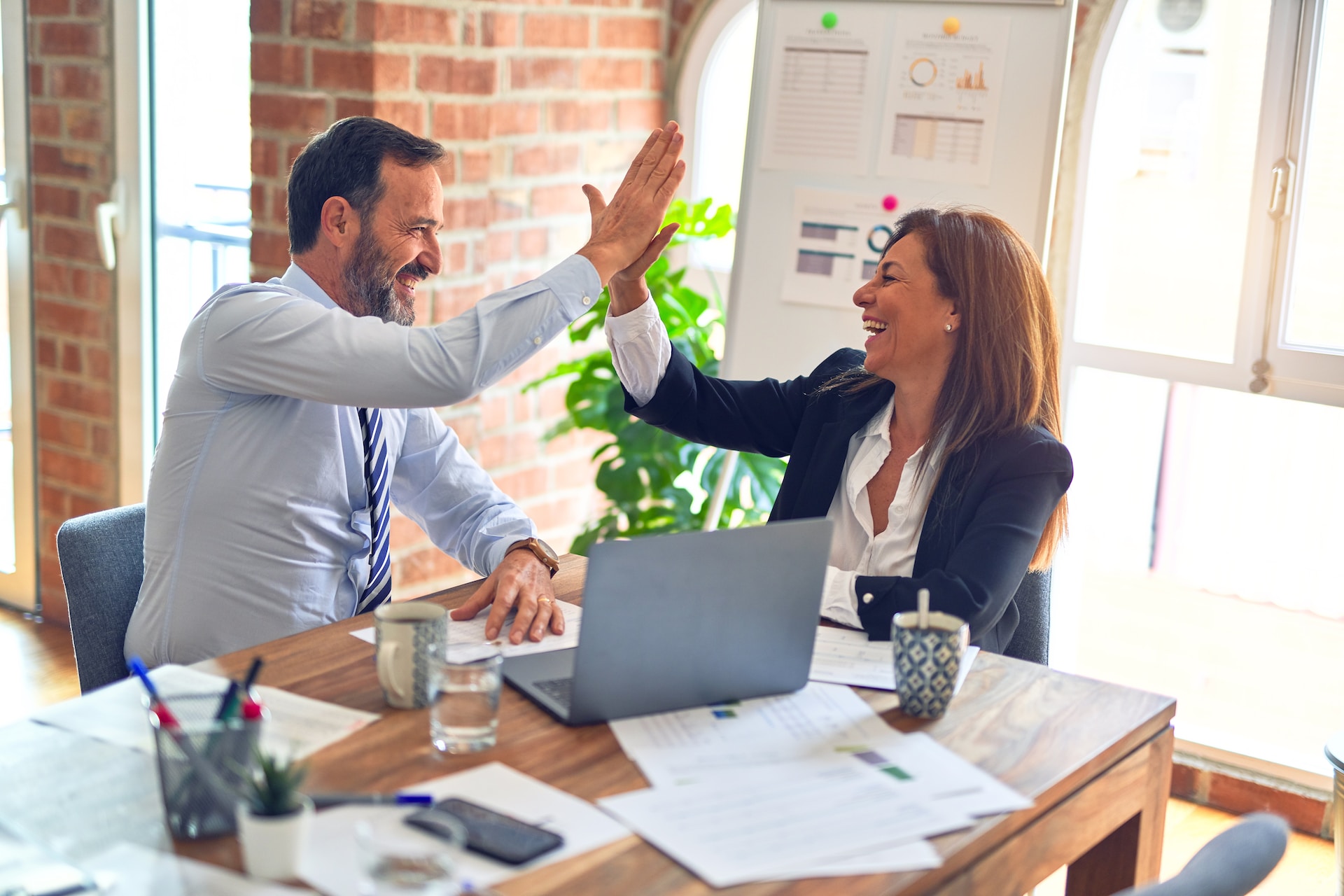 man and women at desk high fiving